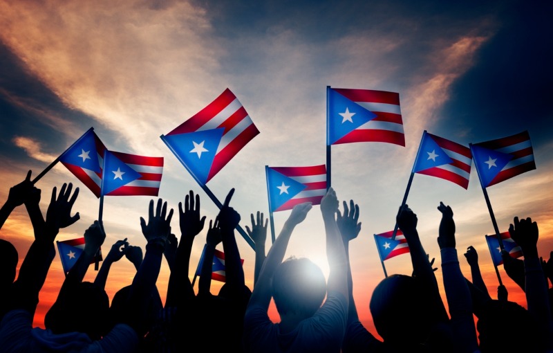 Group of People Waving Flag of Puerto Rico in Back Lit