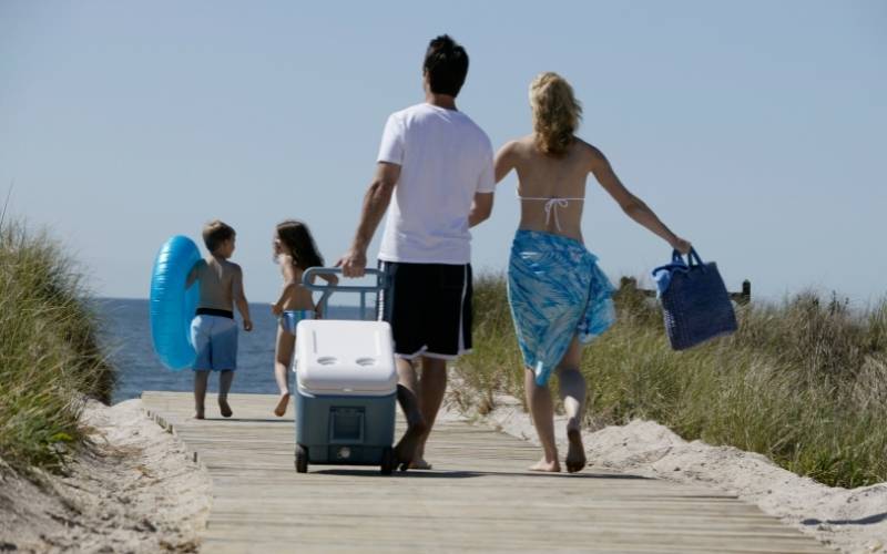 Couple Walking with Cooler and Beach Bag